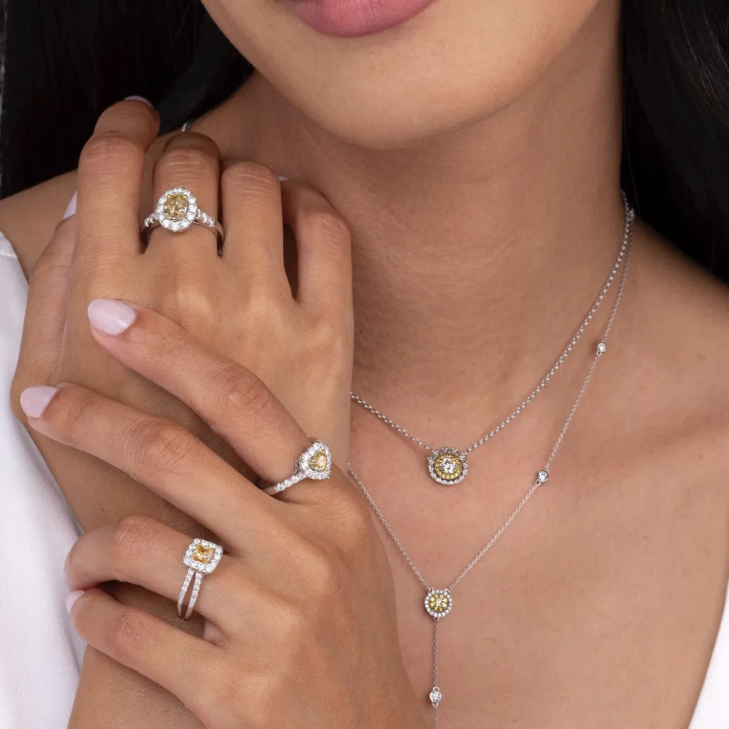 Elegant jewelry display featuring rings and necklaces with yellow gemstones and diamonds.