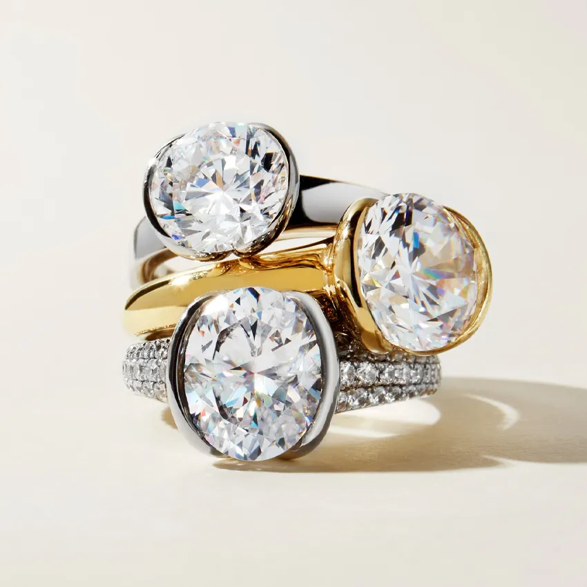 Three elegant rings featuring large, sparkling diamonds in gold and silver settings, showcasing engagement ring options.