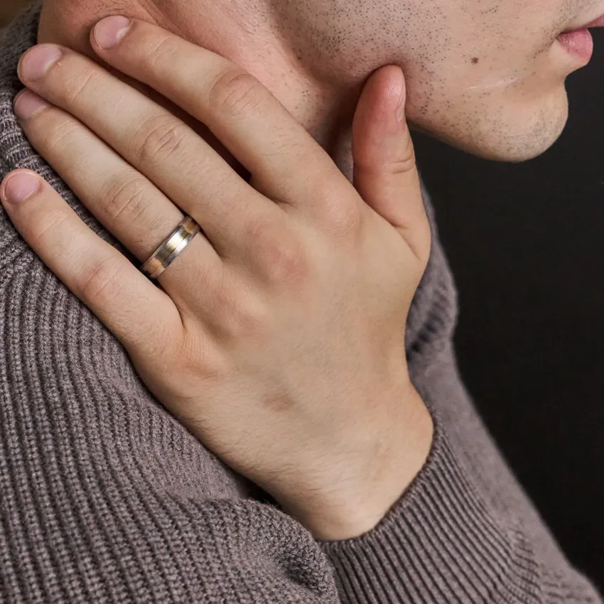 Close-up of a man's hand with a wedding band, showcasing fine jewelry.