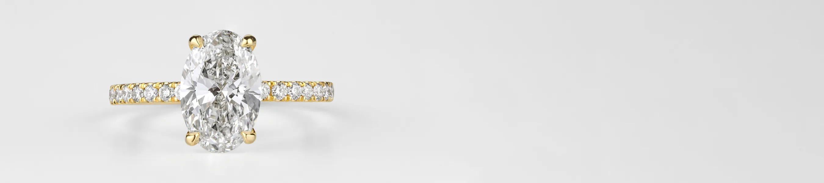 Elegant oval diamond ring with a gold band and smaller diamonds.