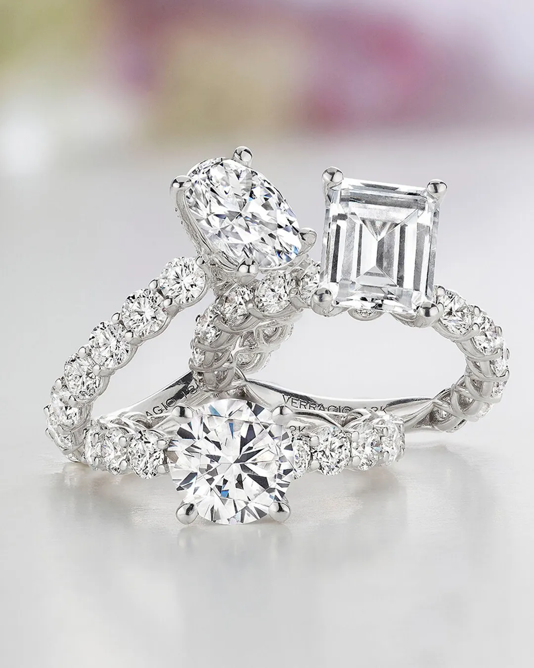 Elegant diamond engagement rings on white floral background. Visit D. Geller & Son Jewelers.