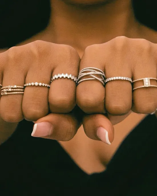 Close-up of hands displaying multiple elegant rings, showcasing various styles and designs.