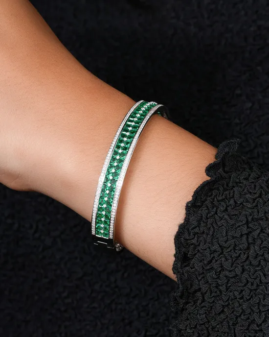 Elegant green gemstone bracelet with silver accents, worn on a wrist against a dark background.