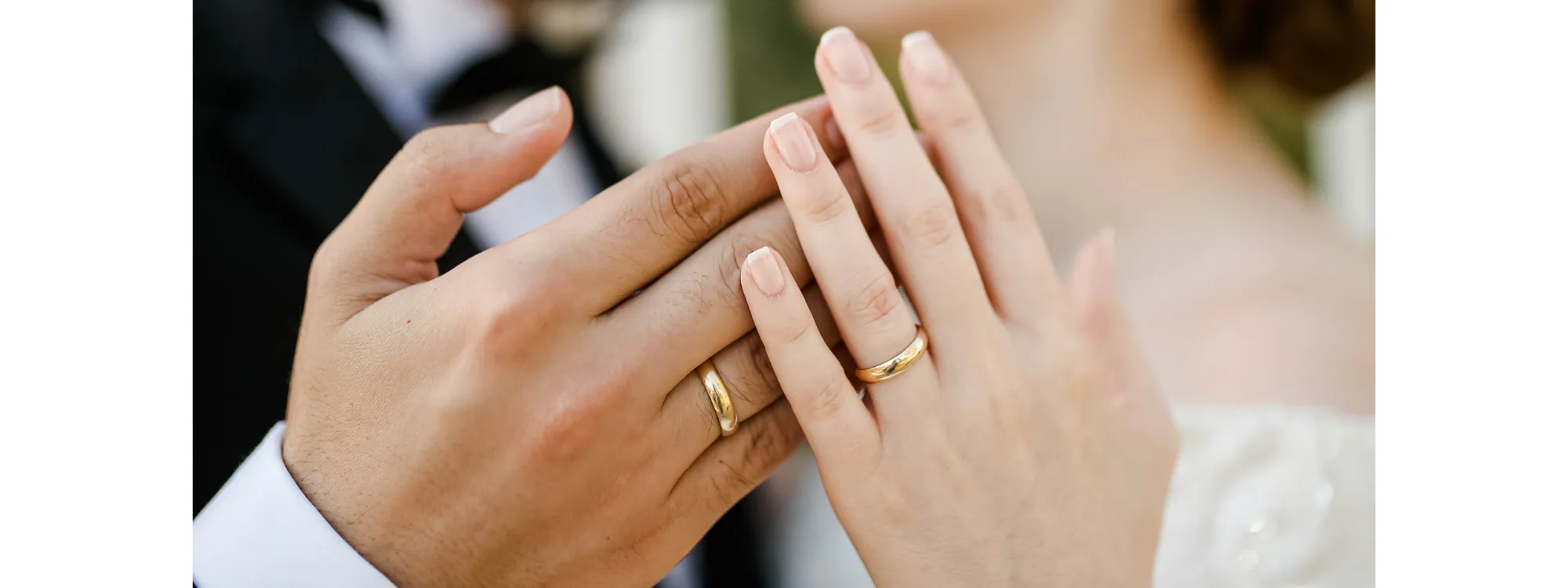 image of bride and groom hands showing gold wedding bands