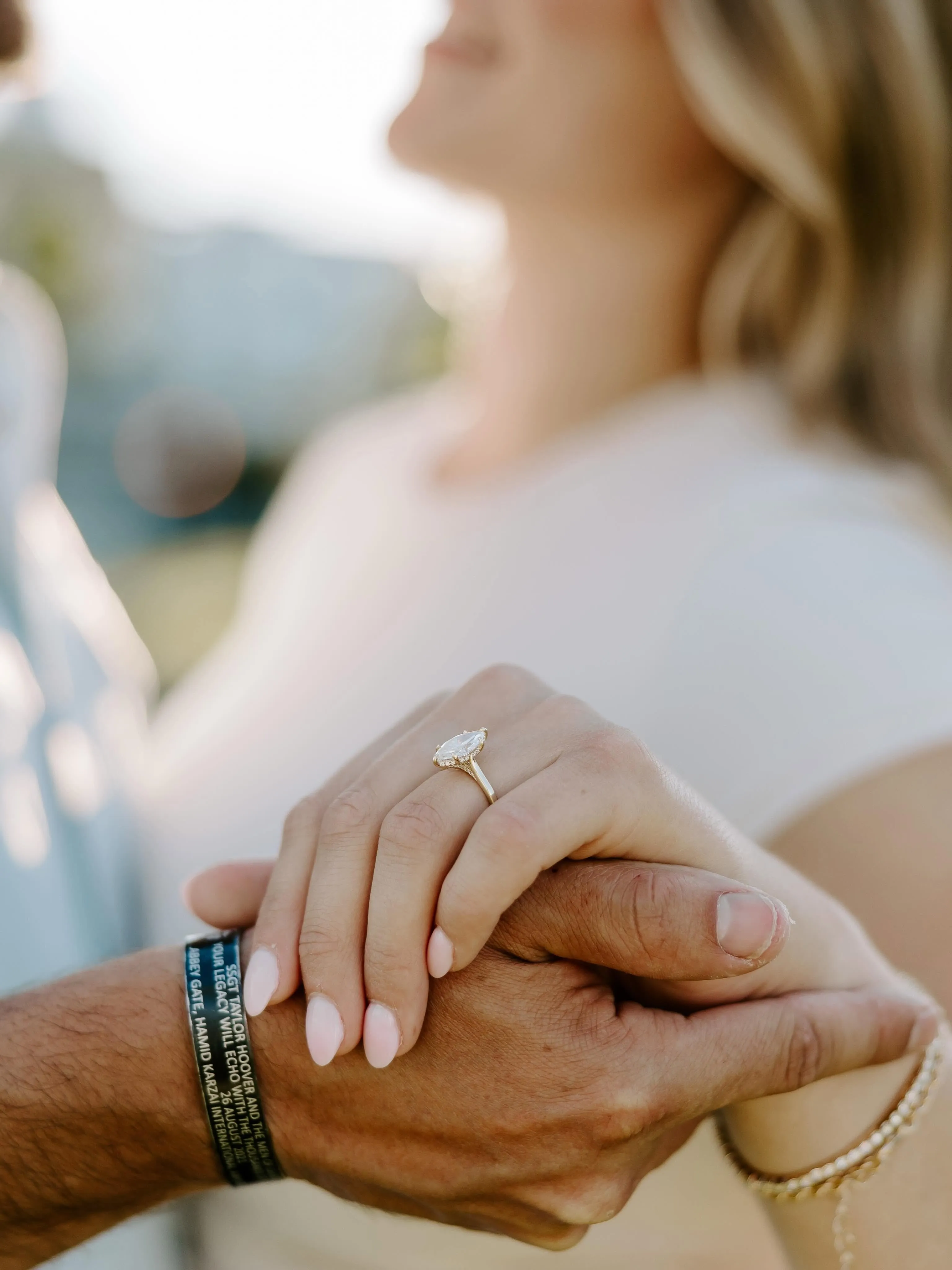 Couple holding hands showing engagement ring