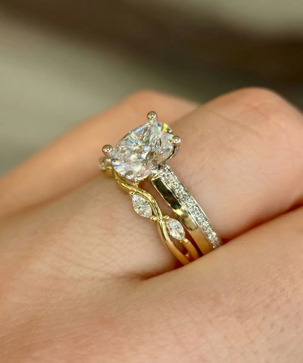 Gold and diamond engagement ring set on a finger, featuring a large central stone.