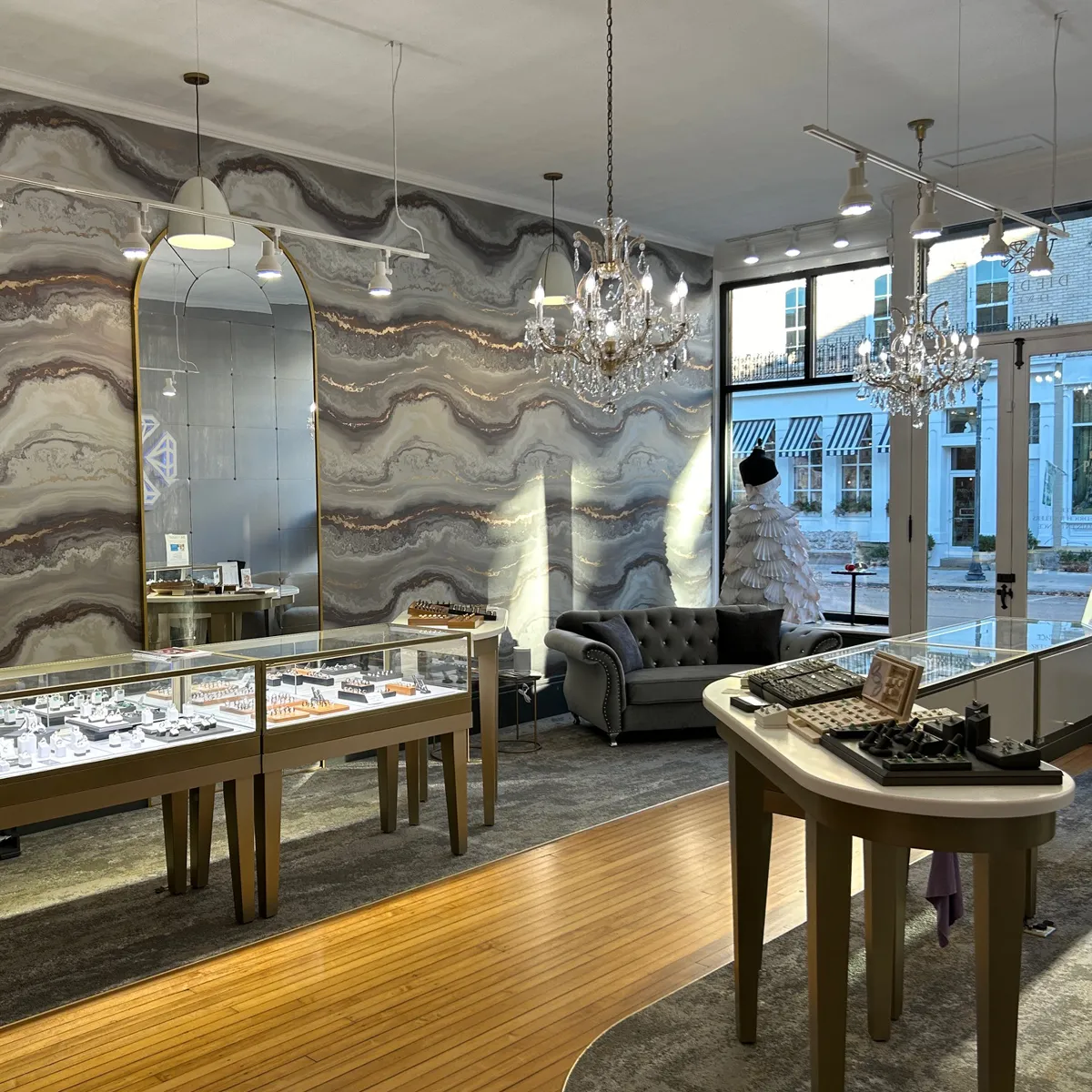 Interior of Diedrich Jewelers with display cases, chandeliers, and a decorative wall.