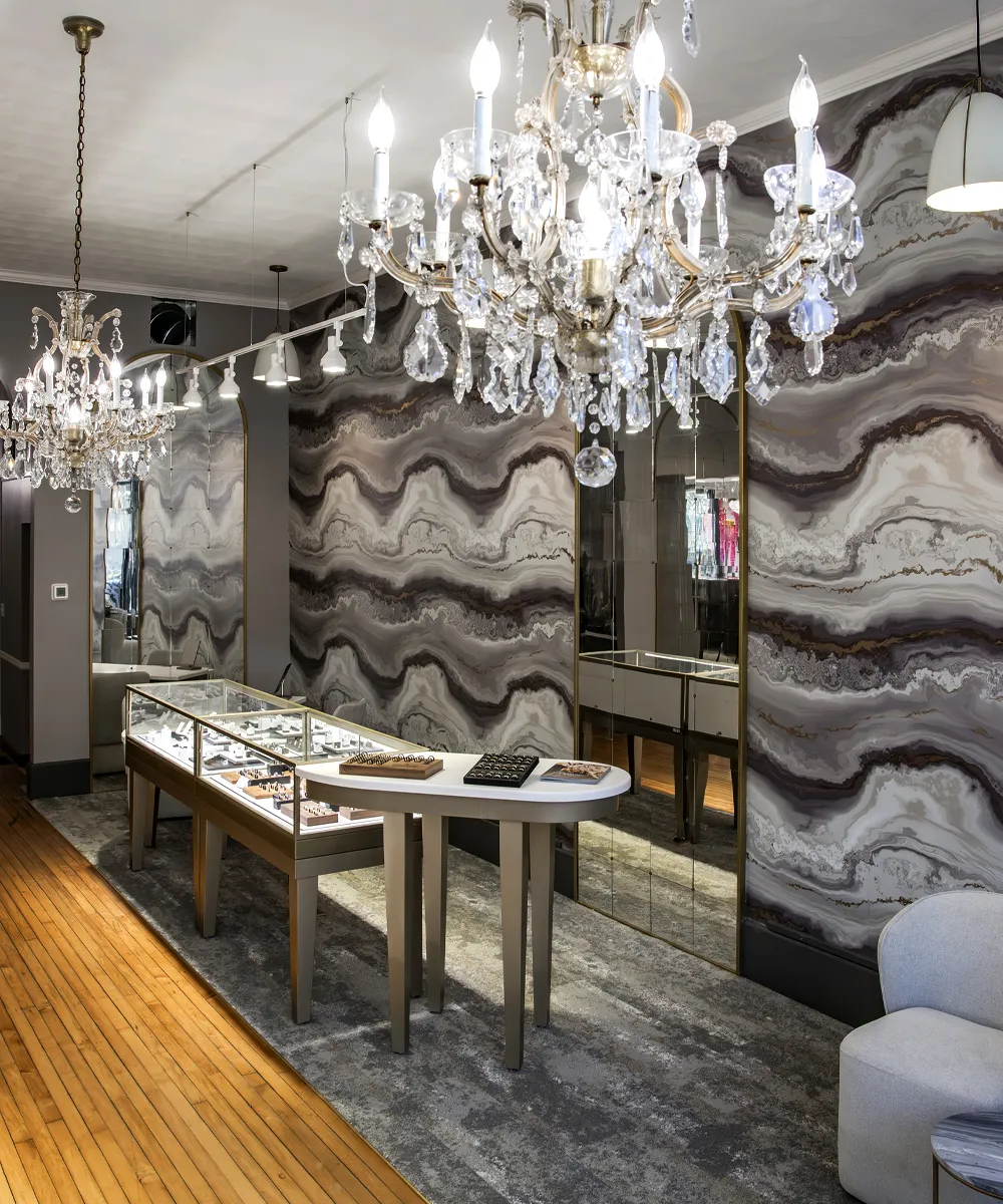 Elegant jewelry store interior with chandeliers, display cases, and marble-patterned walls at Diedrich Jewelers in Ripon.