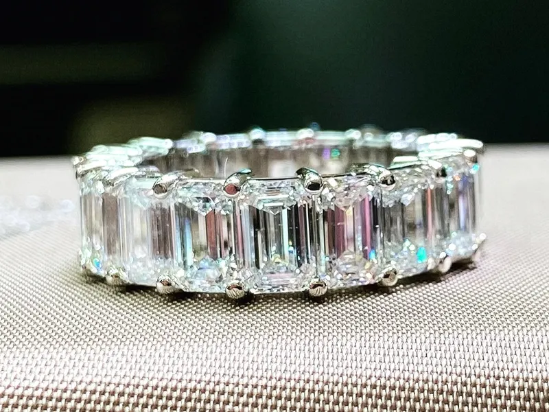 A diamond eternity ring with emerald-cut stones set in platinum.