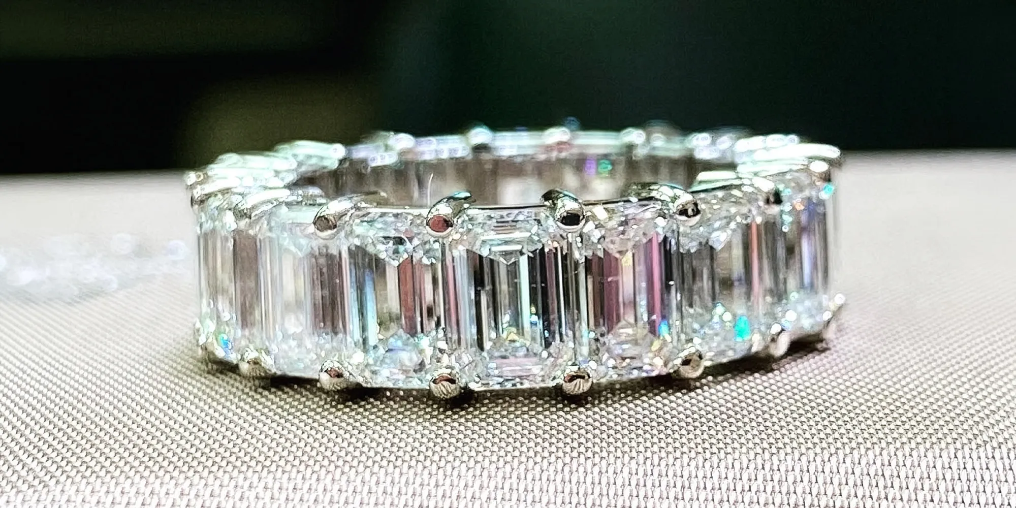 A diamond eternity ring with emerald-cut stones set in platinum.