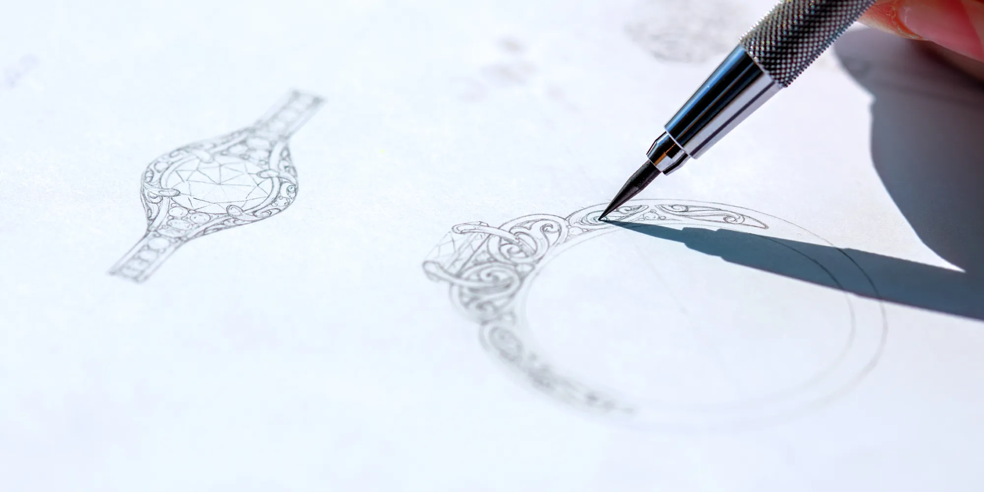 A detailed sketch of a ring design being drawn with a mechanical pencil.