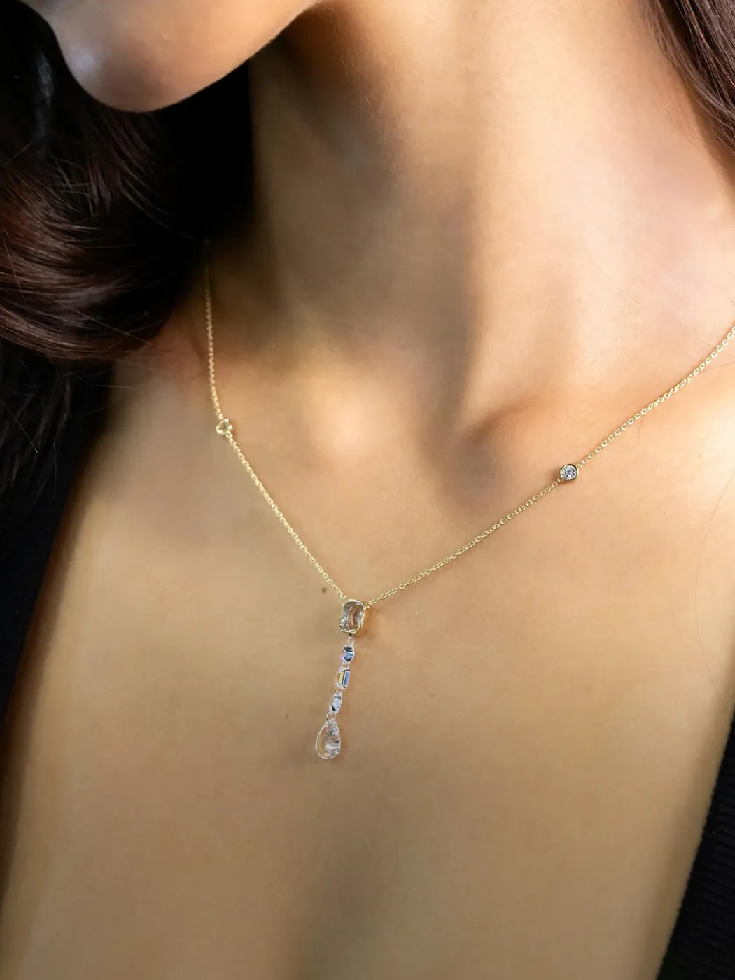 Elegant gold necklace with a diamond pendant on a woman's neck.