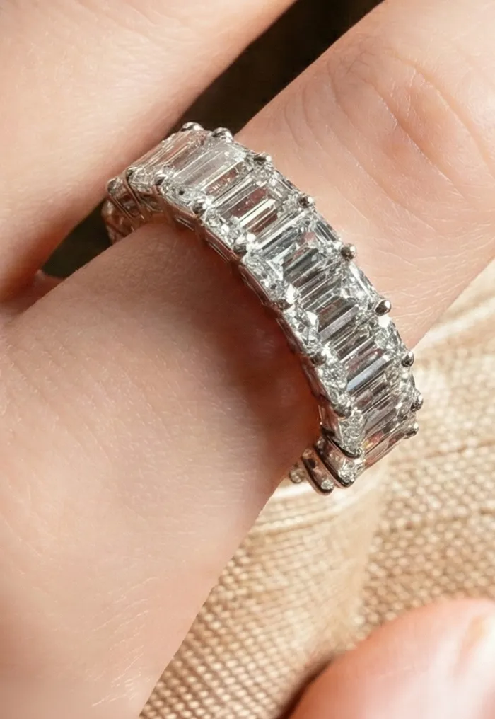 Hand with a textured, sparkling ring.