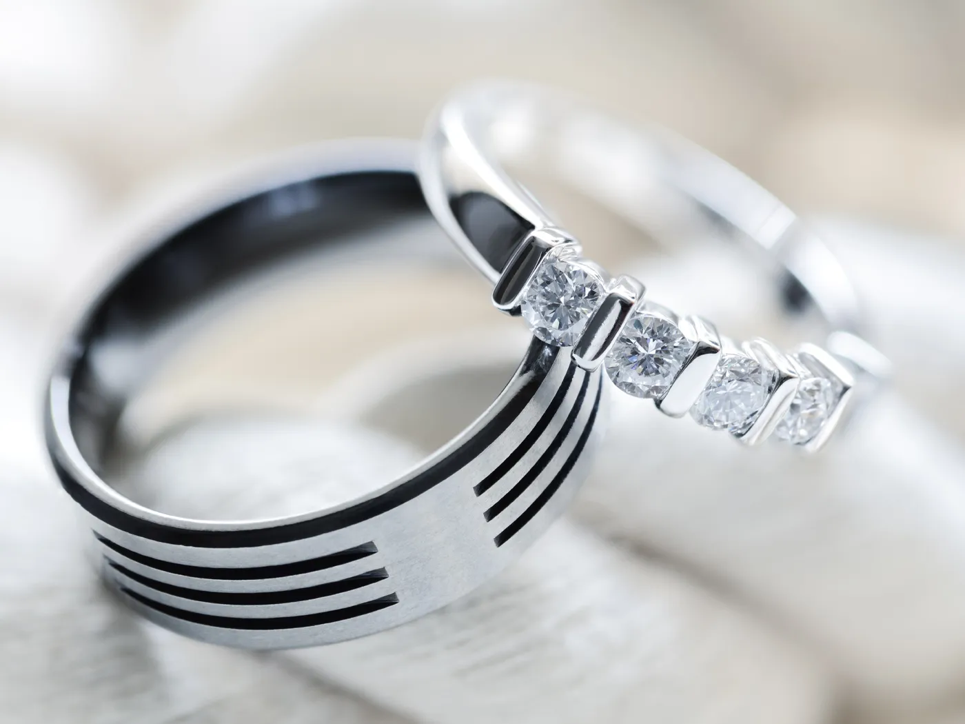 Elegant wedding rings featuring a sleek black band and a diamond-studded white band.