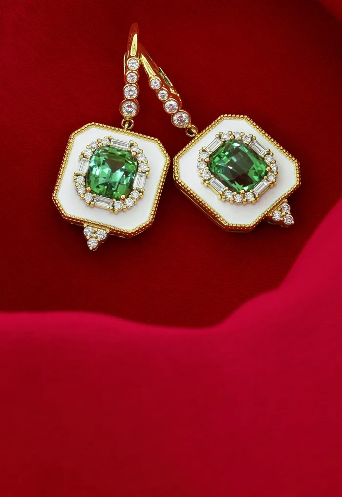 Elegant green gemstone earrings with diamonds on a red fabric background.