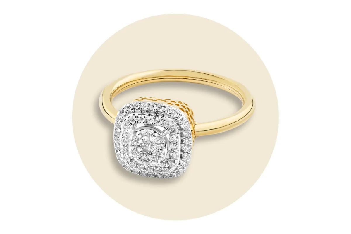 Estate gold ring with a square diamond cluster setting on a beige background.