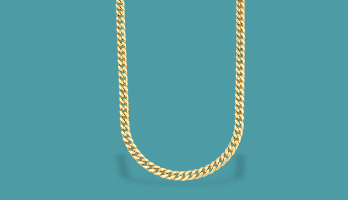 Gold chain necklace displayed against a teal background, showcasing its shine and intricate design.