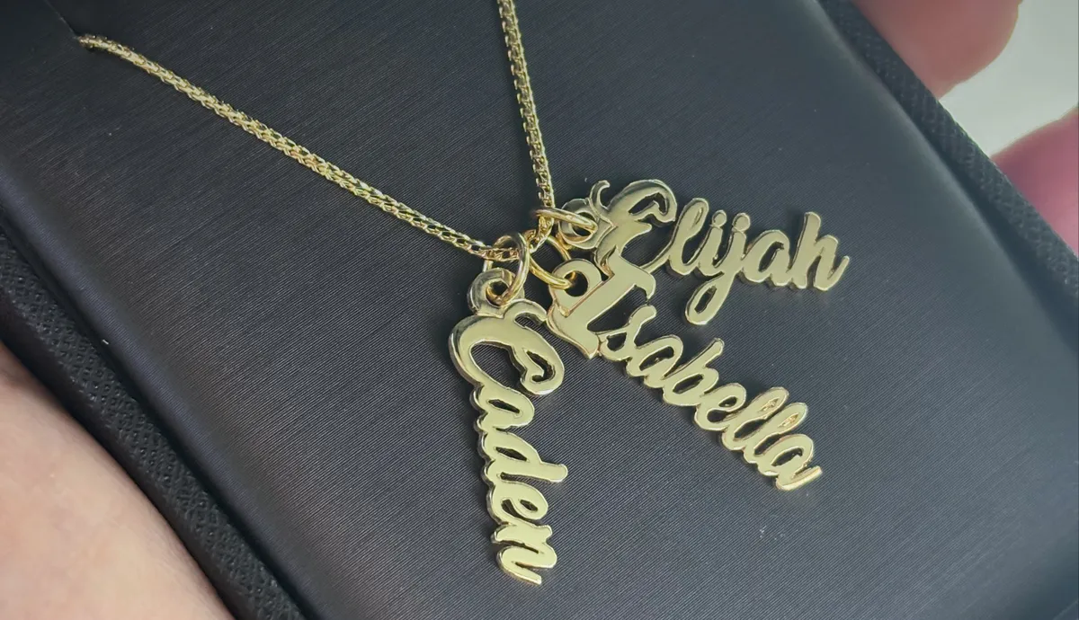 Gold necklace with three name pendants: Elijah, Isabella, and Caden. Perfect for personalized jewelry.