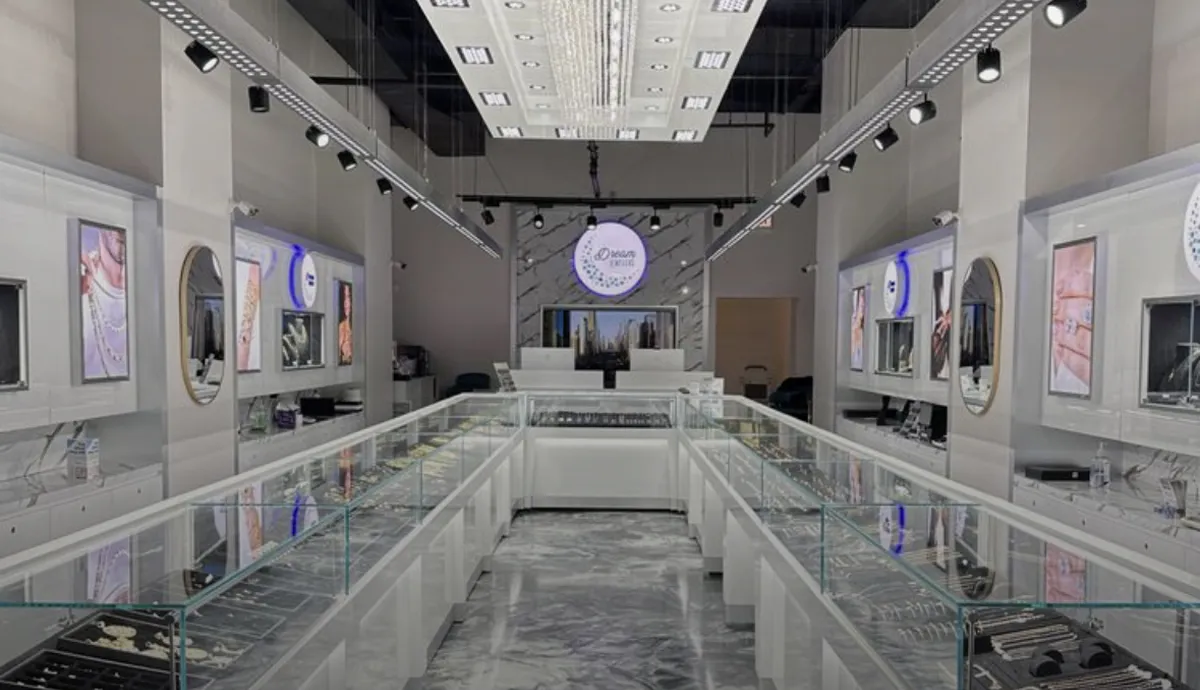 Modern jewelry store interior with display cases, bright lighting, and framed jewelry images.