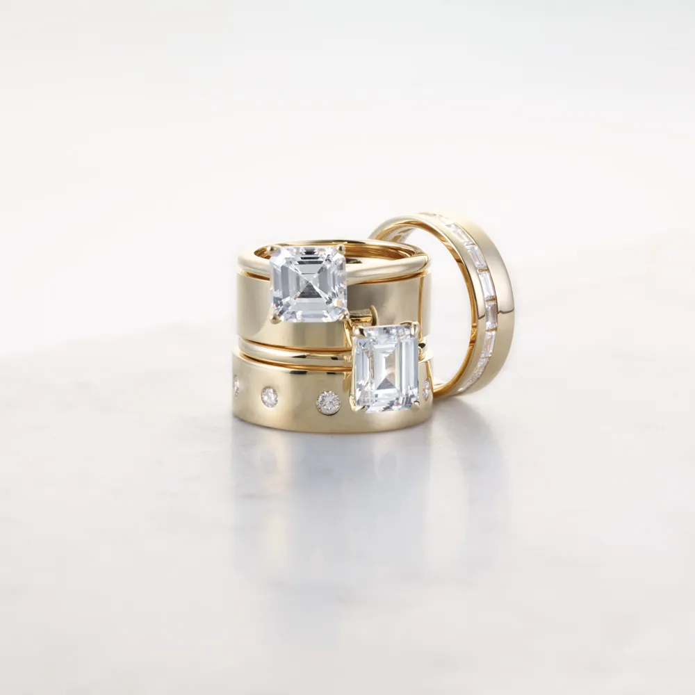 Elegant gold rings with large square diamonds, showcasing a luxurious jewelry collection.