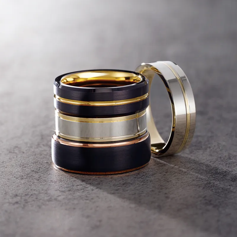 Stylish men's wedding bands in gold and black, showcasing modern design.