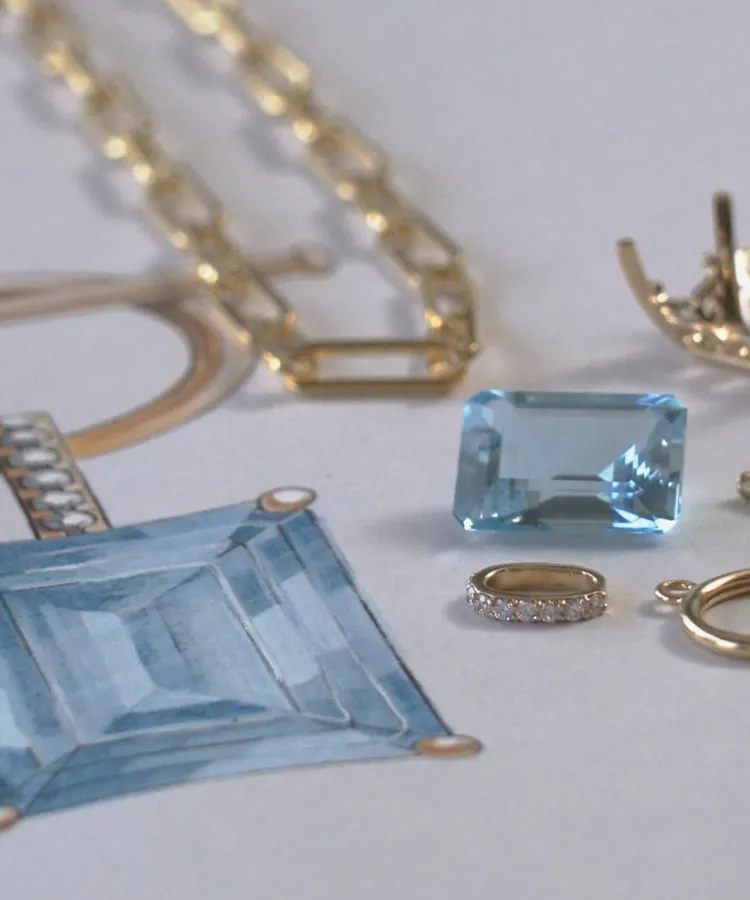 Jewelry design featuring a blue gemstone, gold chain, and diamond ring on a sketch background.