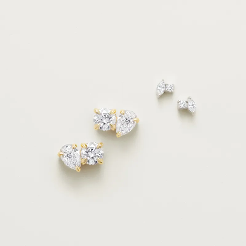 Three diamond stud earrings in gold settings, showcasing elegant designs.