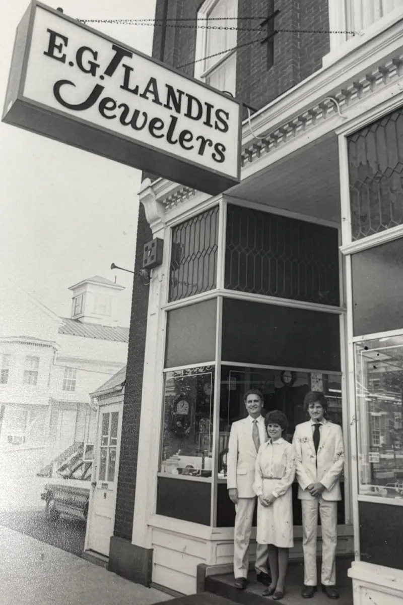E.G. Landis Jewelers storefront with three staff members in vintage attire, showcasing fine jewelry in Gilbertsville.