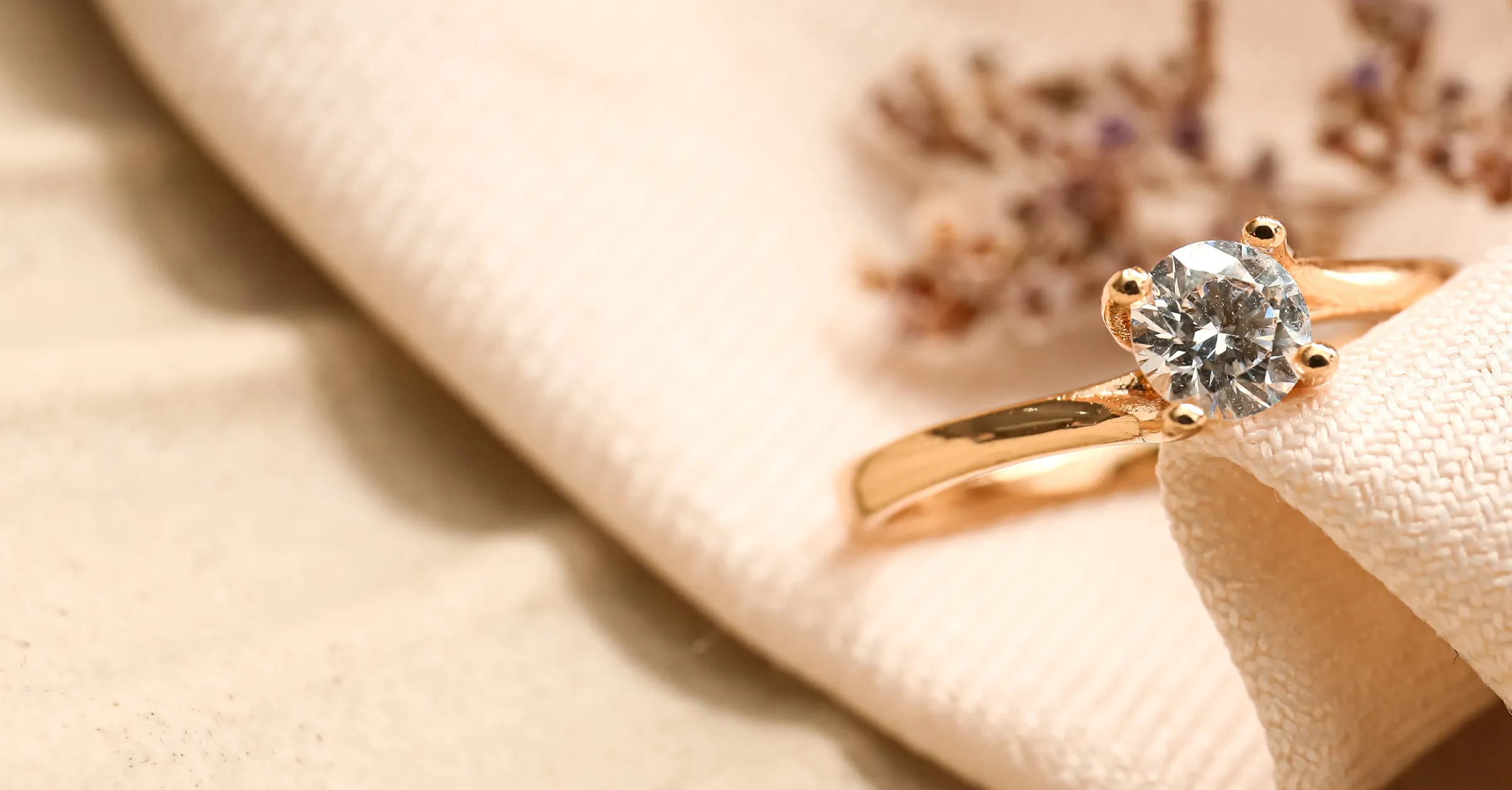 A sparkling diamond engagement ring rests on vibrant orange flowers. Click to read more testimonials from E.G. Landis Jewelers.