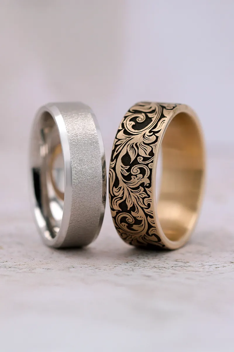 Close-up of a silver and gold wedding band set, showcasing intricate designs and textures.