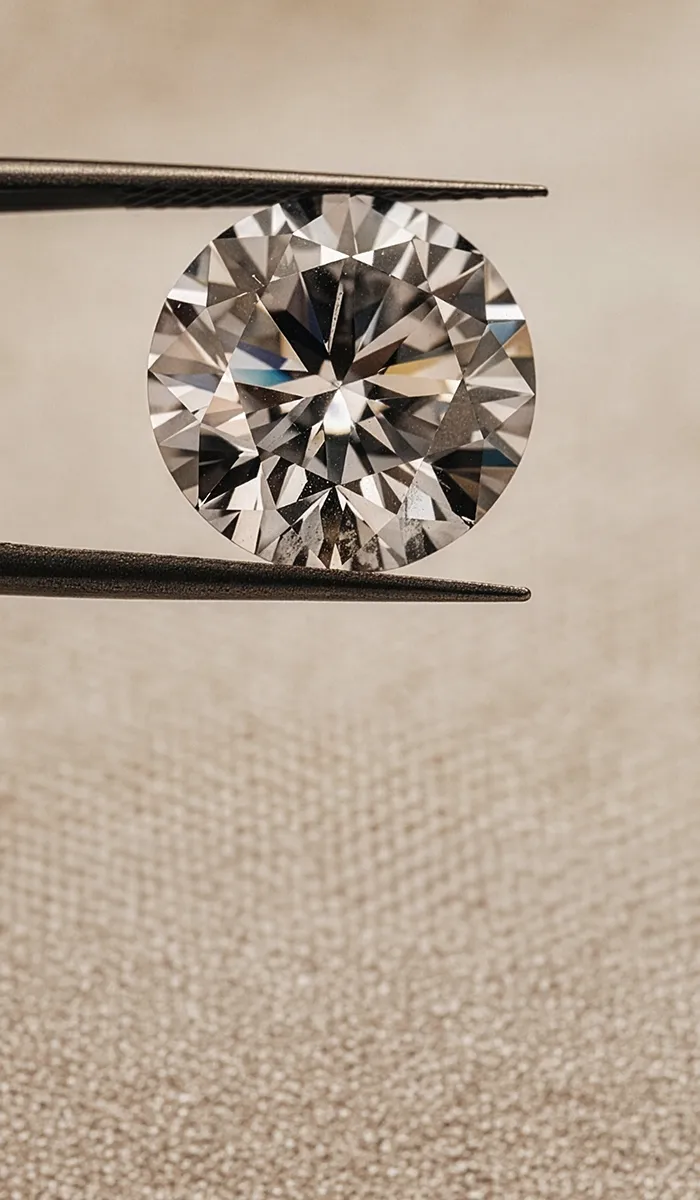Diamond held by tweezers with three more diamonds blurred in the background. Browse the Inventory.