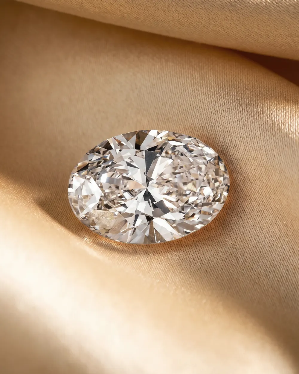 Oval diamond on gold satin fabric.