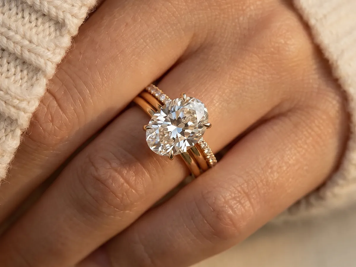 Close-up of a hand wearing a large diamond ring with a gold band. Learn more about the Everlasting Protection Plan.