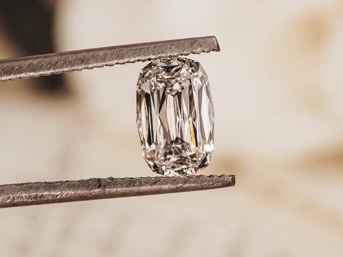 Diamond held by tweezers, showcasing its clarity and cut. Learn more about Erley Diamonds' trade-in program.