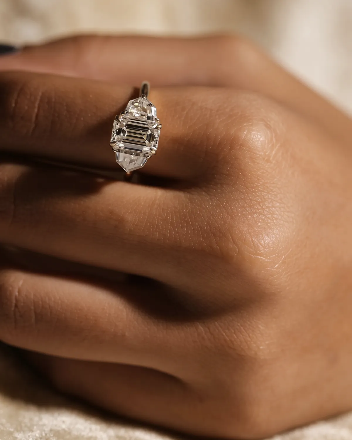 A hand wearing a unique, multi-stone diamond ring from Erley Diamonds.