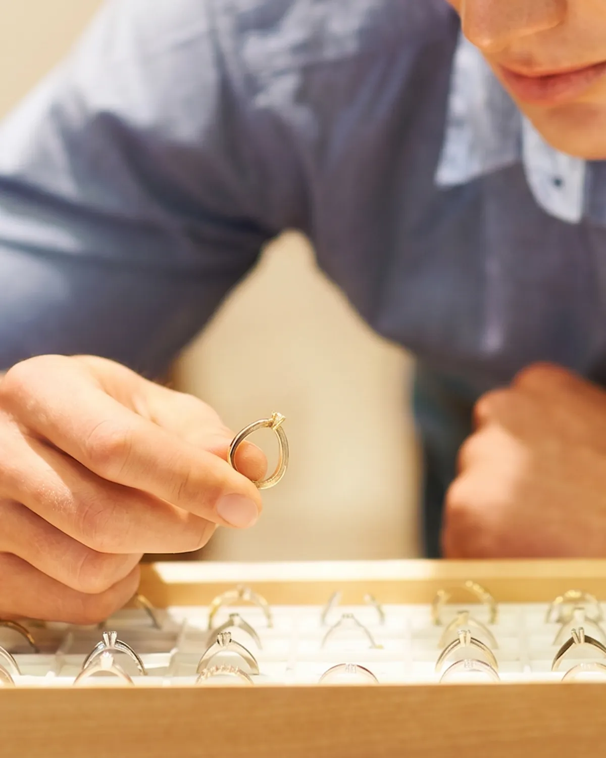 A person examines a ring from a jewelry display case at Erley Diamonds in Phoenix.