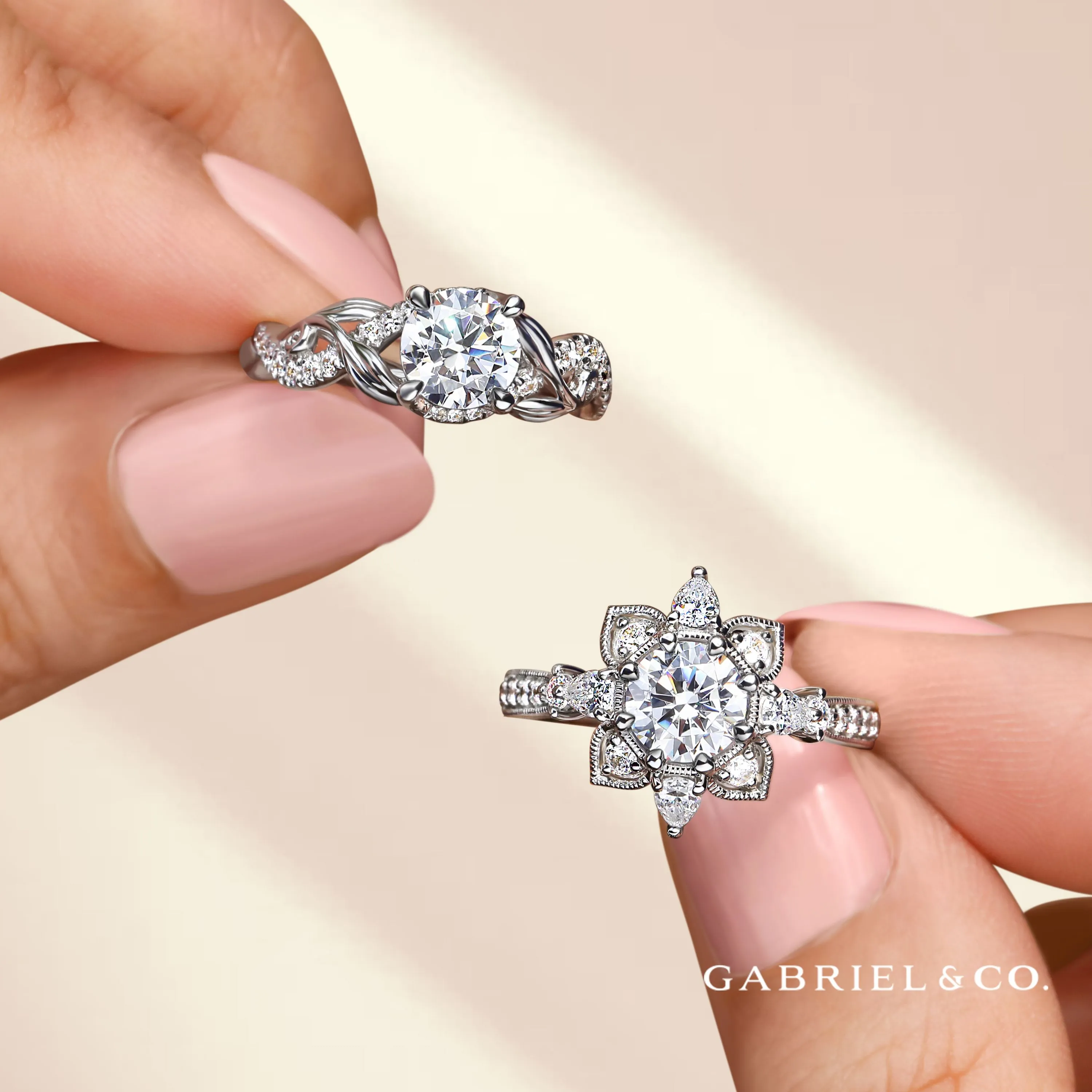 Two elegant semi-mount engagement rings held in a hand, showcasing intricate designs and sparkling stones. Shop Now at Falls Jew