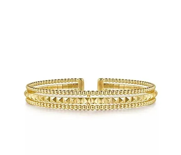 Gold cuff bracelet with textured design, featuring beaded and pyramid patterns.