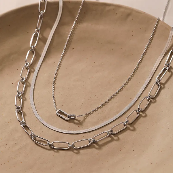 Silver necklaces displayed on a beige plate, promoting Falls Jewelers' silver jewelry collection. Click to shop now.