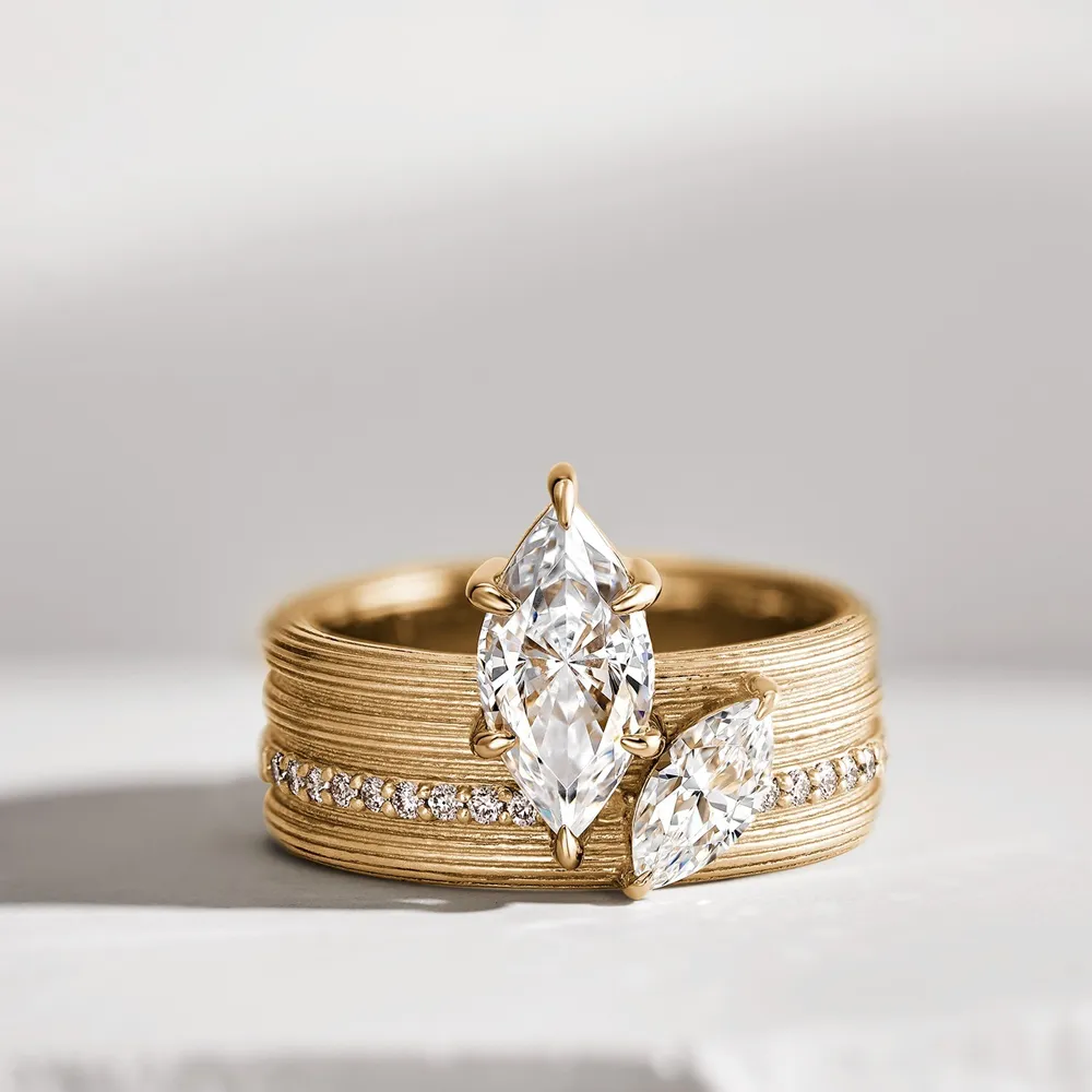 Elegant gold engagement ring with two marquise-cut diamonds and a row of smaller diamonds.