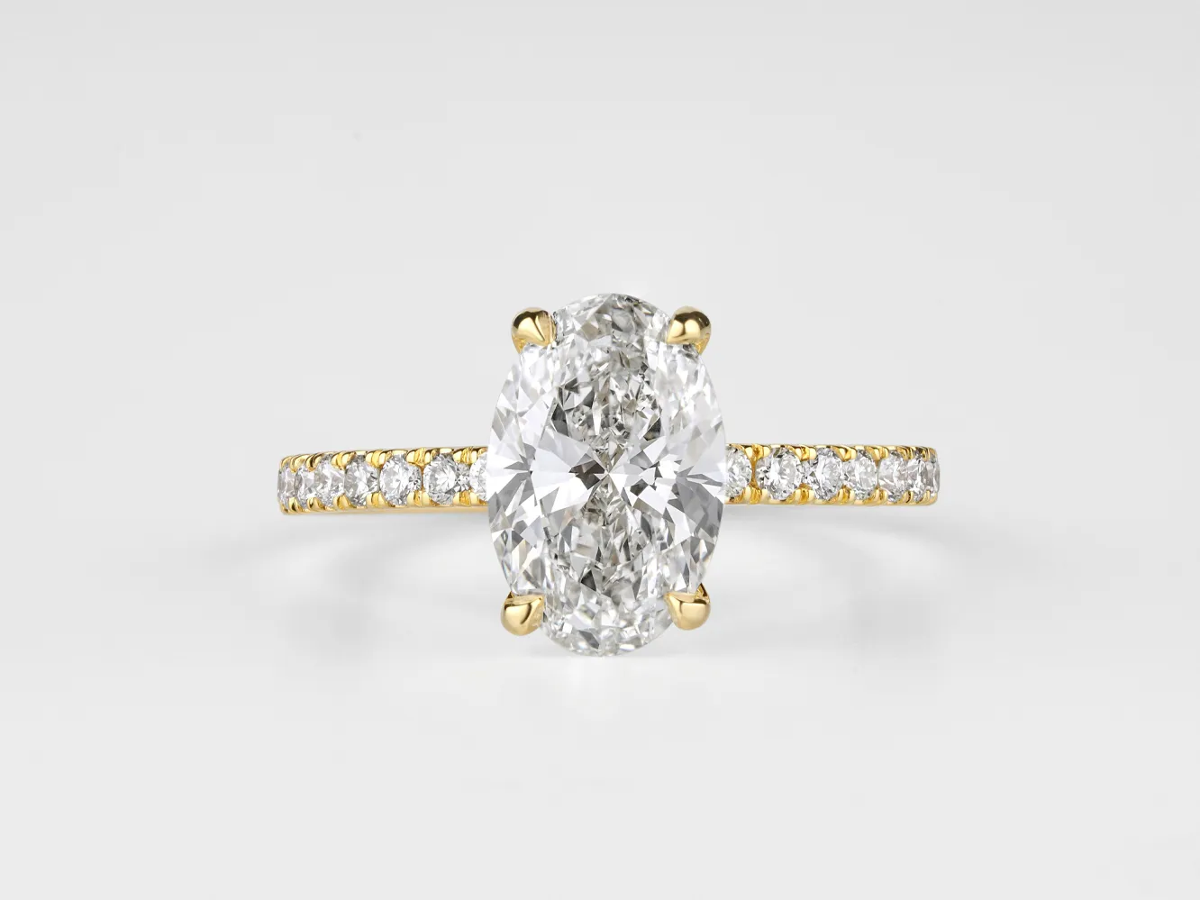 Elegant oval diamond ring with a gold band and sparkling side stones, perfect for engagement or special occasions.