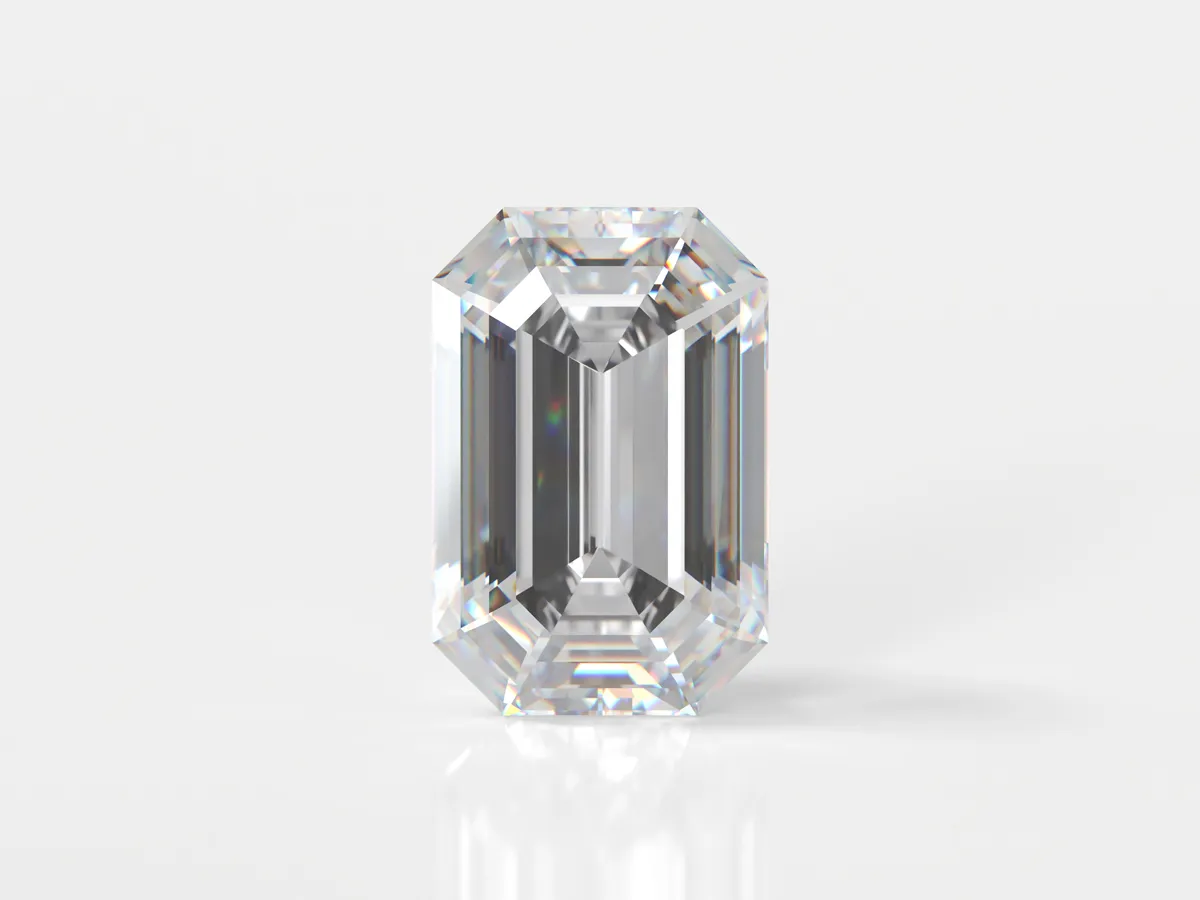 Clear emerald-cut diamond on a white background. Click to explore more at Flora Gems, your jewelry store in Decatur & Champaign,