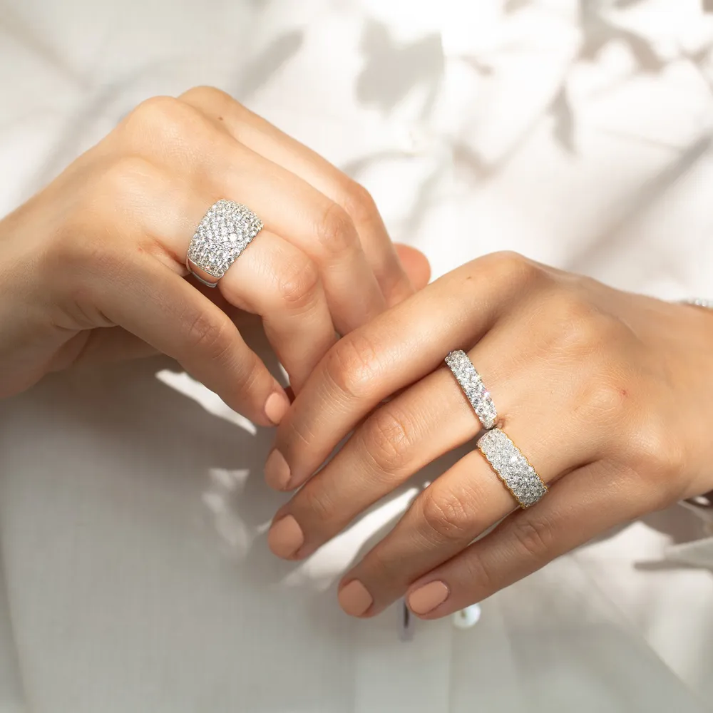 Two hands adorned with sparkling diamond rings, showcasing elegant jewelry.