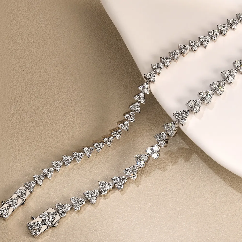 Elegant diamond bracelet with triangular stones, displayed on a neutral background.