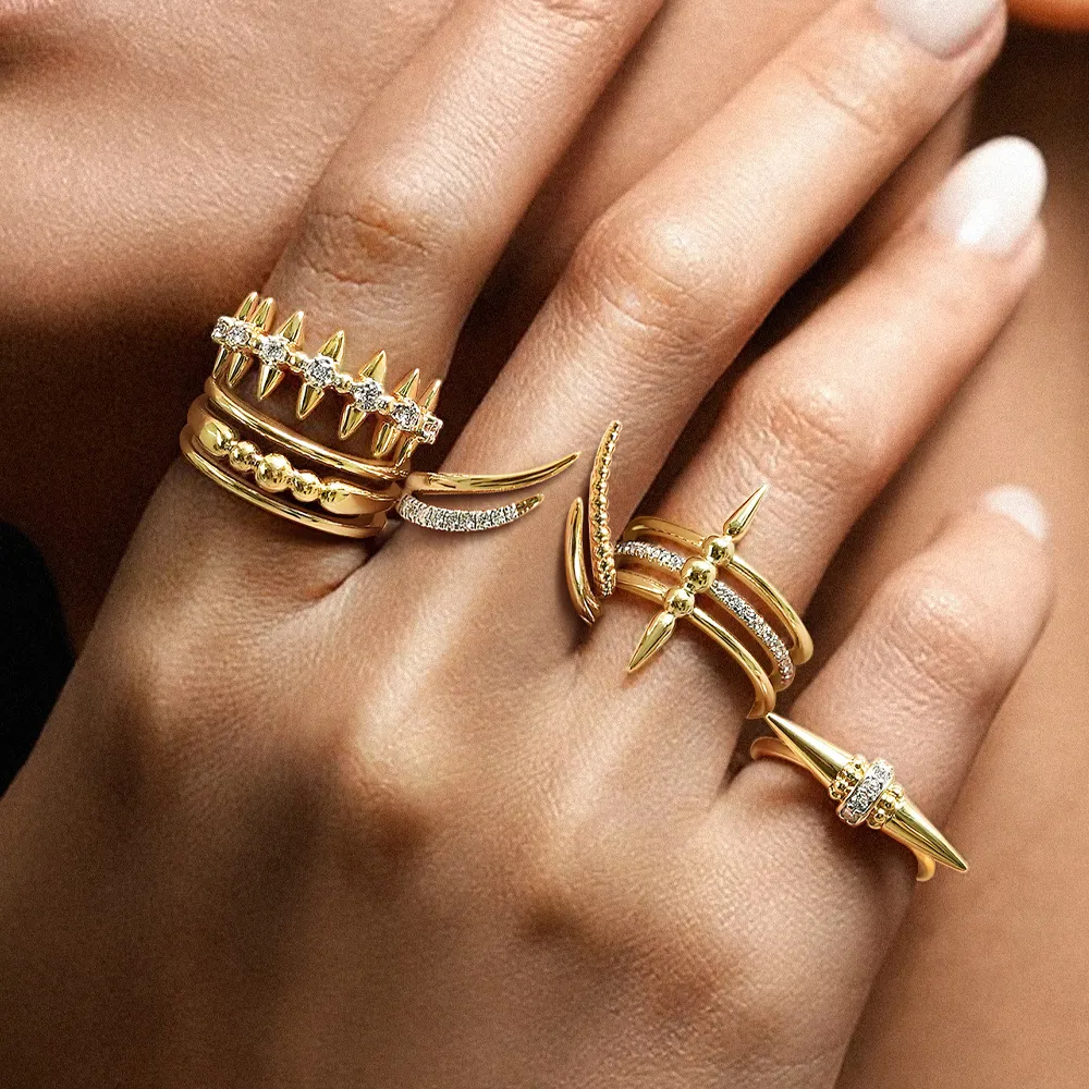 Stylish gold rings with spikes and diamonds on a hand, showcasing unique jewelry designs.