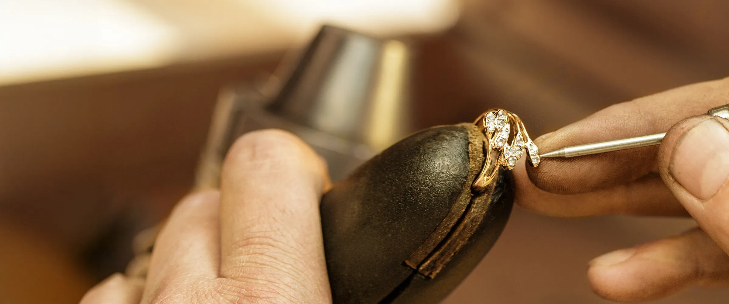 Jeweler restoring a vintage ring with diamonds, showcasing craftsmanship.