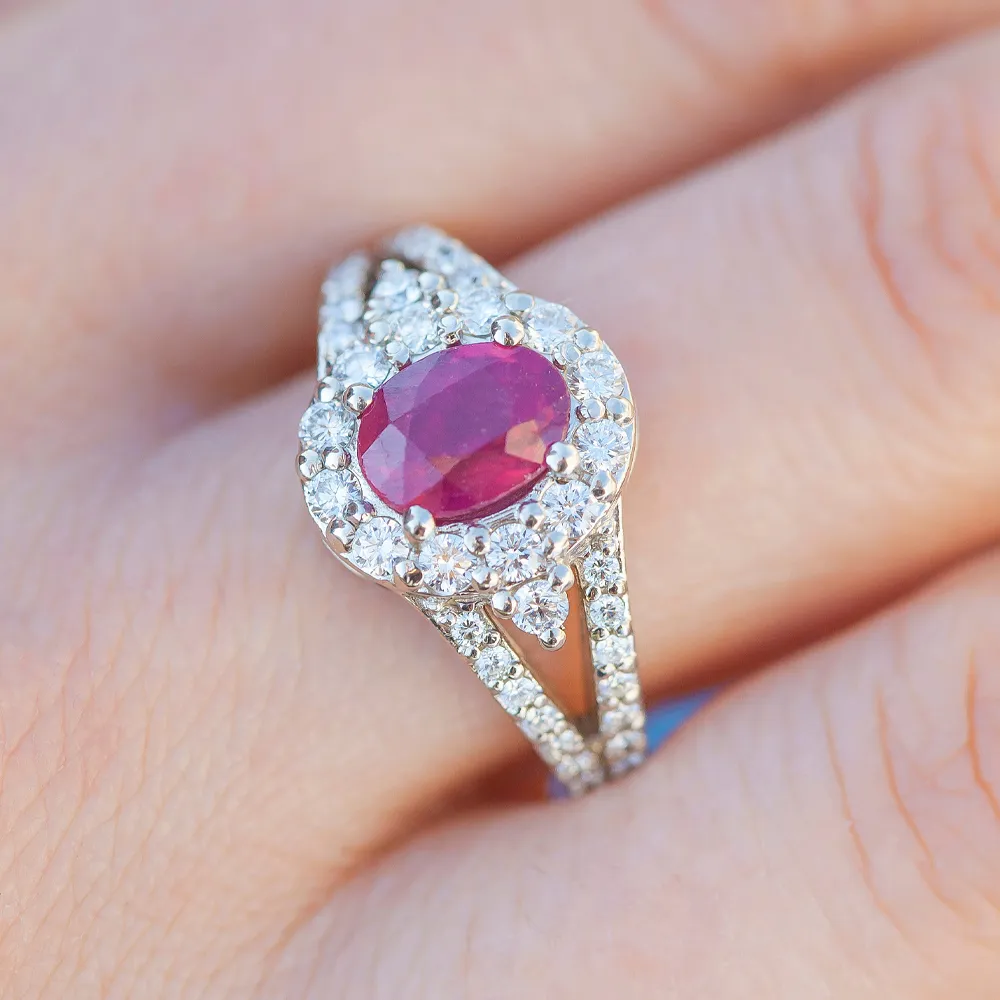 Elegant ring featuring a central ruby surrounded by sparkling diamonds, showcased on a hand.