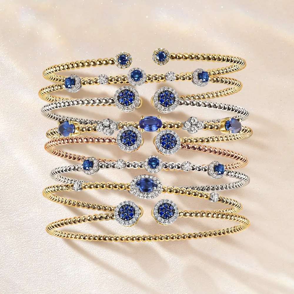 Elegant stack of gemstone bracelets featuring blue stones and gold/silver bands.