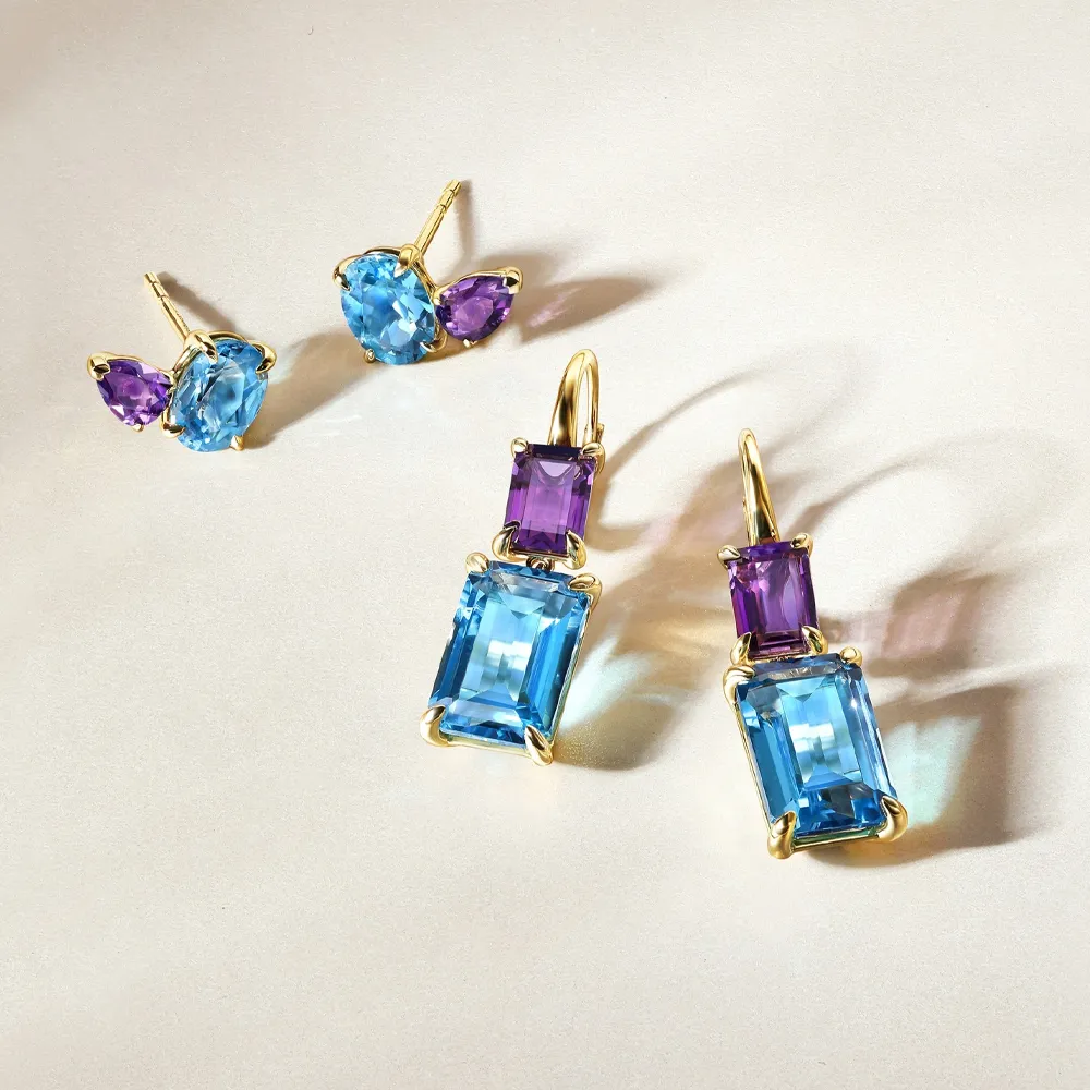 Gold earrings featuring blue and purple gemstones, showcasing elegant designs.