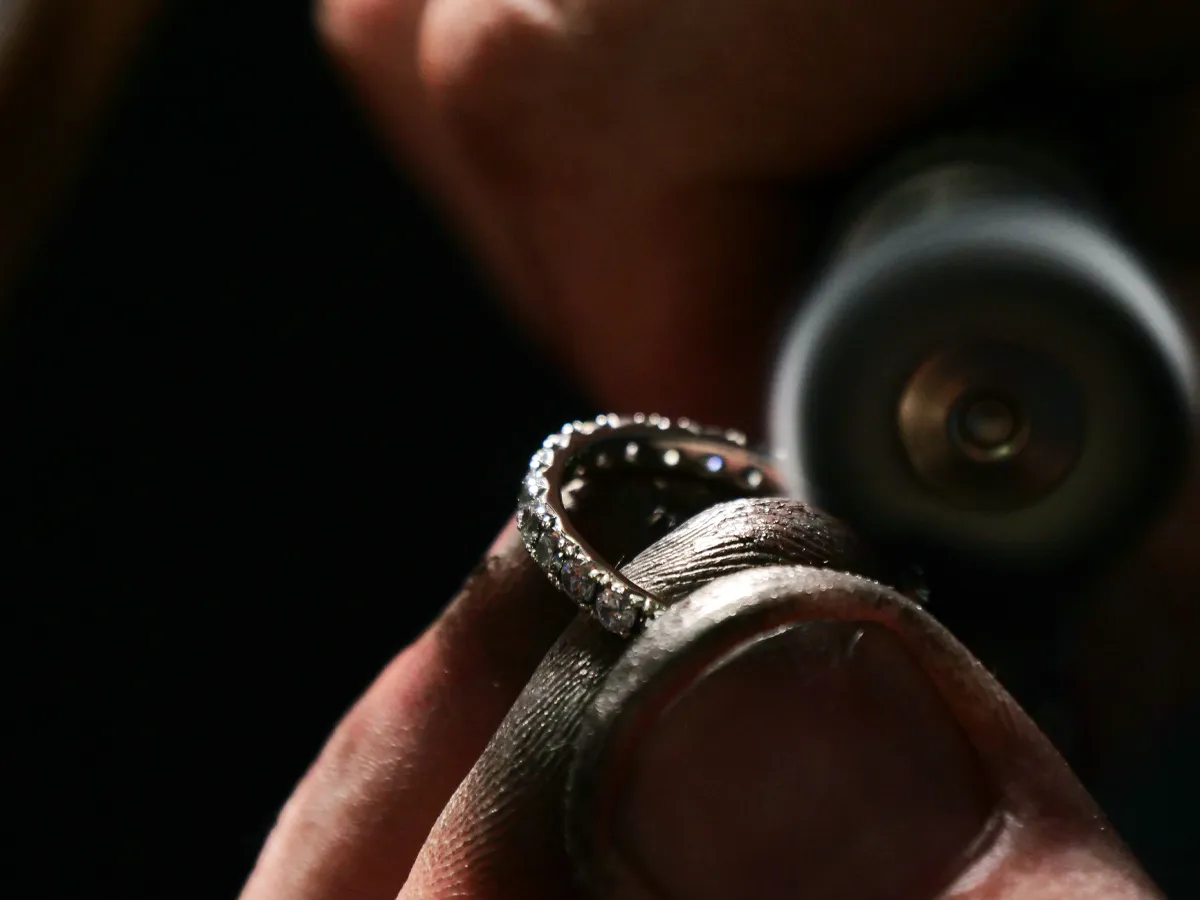 Close-up of a jeweler repairing a diamond ring at Flora Gems, your trusted jewelry store in Decatur & Champaign, IL.